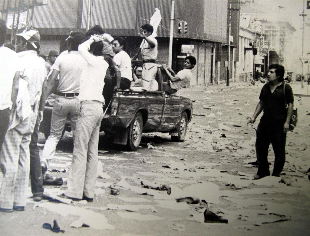 30 mars 1980 · Évacuation en pick-up pendant les funérailles de Monseigneur Romero. Le drapeau indique la neutralité des secouristes. Photo : Francisco Campos · Tous droits réservés.