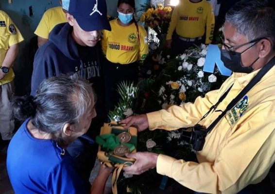 Campos entrega medal a mamá de manuel. 
