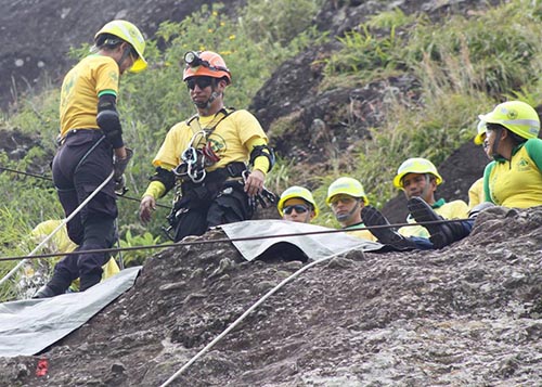 Equipo de los Comandos con cascos y cuerdas durante un rescate en una ladera rocosa.