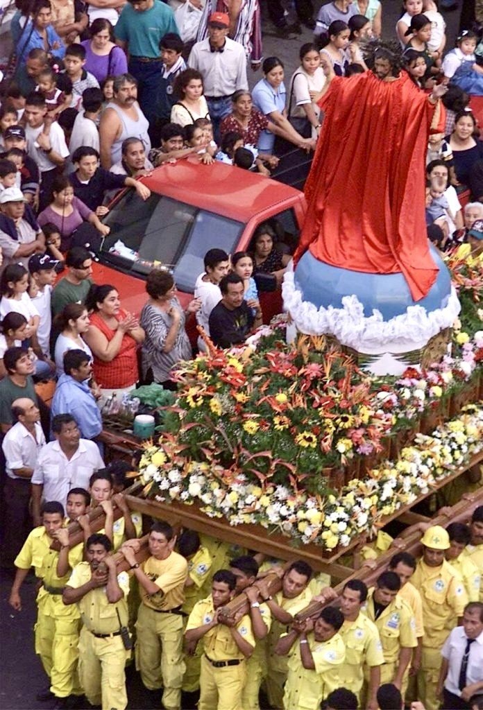 Comandos llevan sobre sus hombros las andas con la imagen del Divino Salvador del Mundo entre la multitud.
