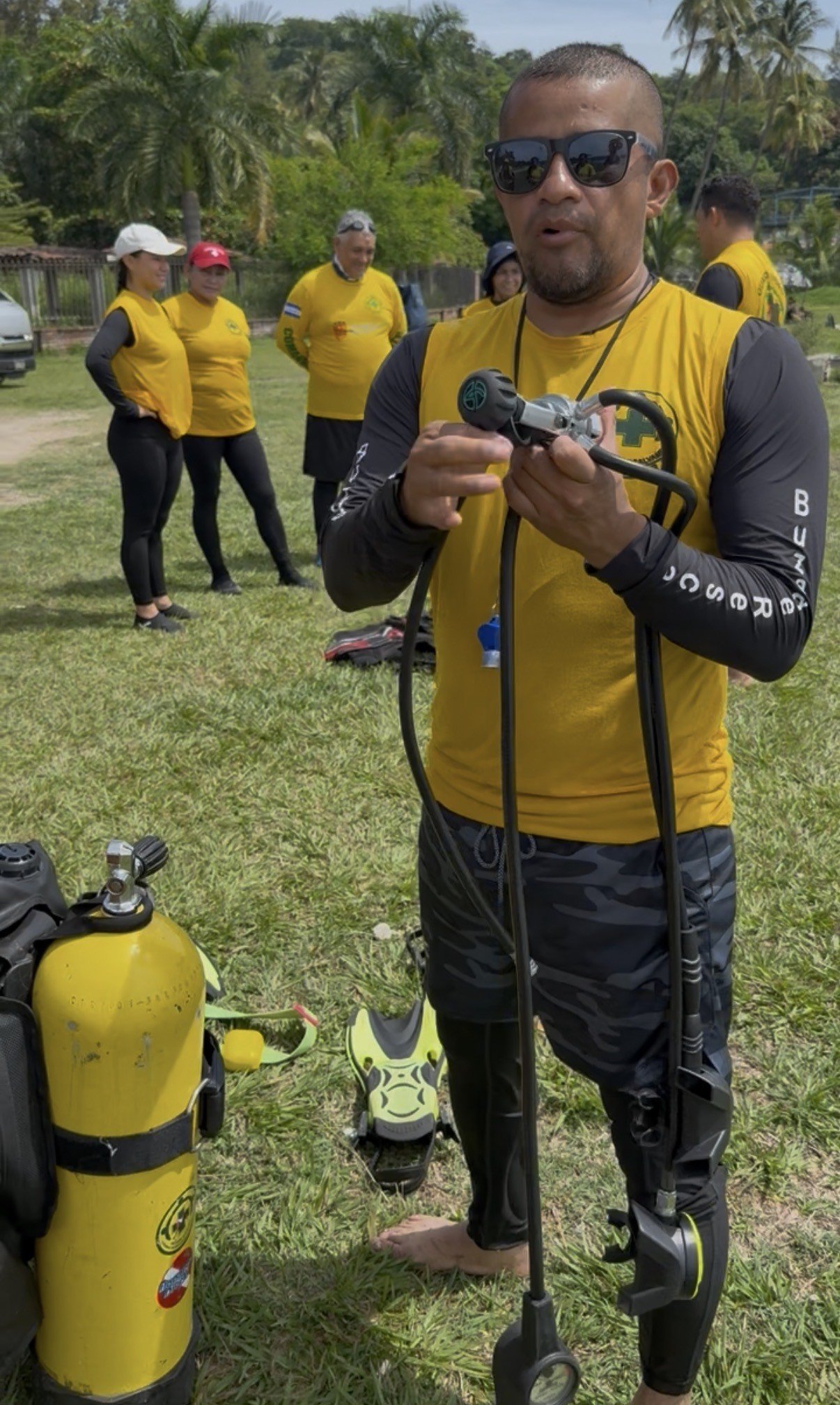 Kelvin Valladares, responsable de l’équipe de plongée et de sauvetage, présente du matériel de plongée avec ses collègues.