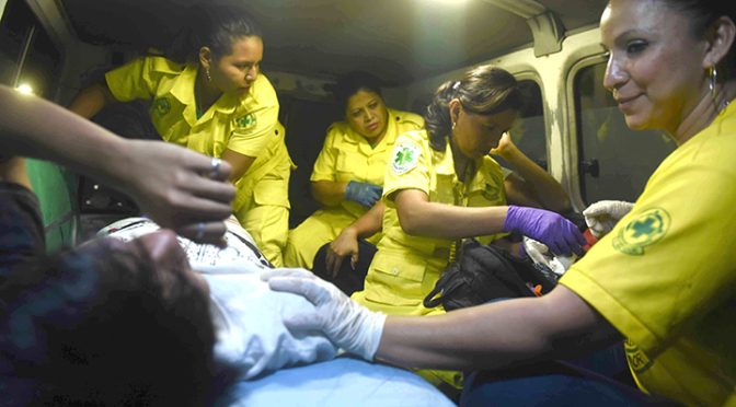Socorristas de Comandos de Salvamento atienden a una persona dentro de una ambulancia.